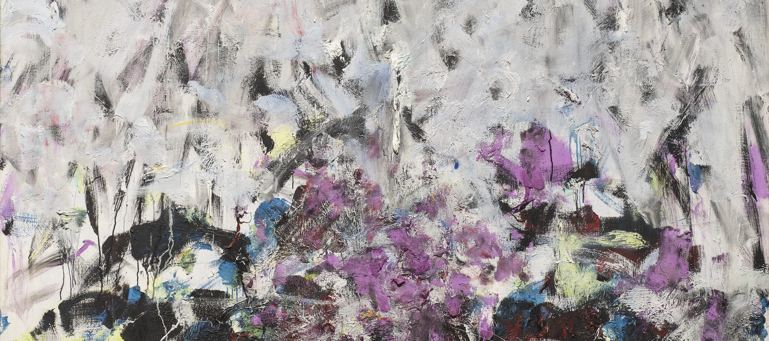A vertical, abstraction features broadly painted strokes of pale gray, lavender, and cobalt in the upper two-thirds of the canvas. The colors continue in the lower third, along with touches of green, black, and other hues, but the expressive brushwork becomes denser and chaotic.