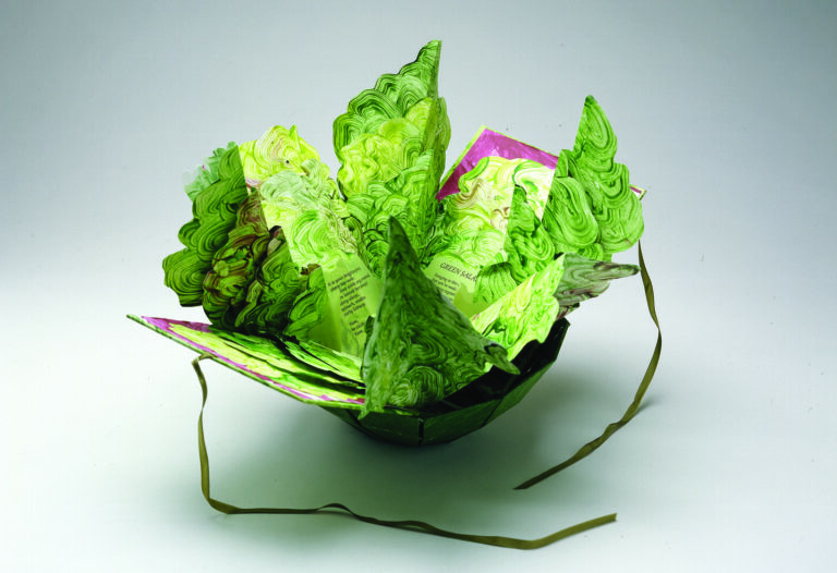 Artist's book resembling a salad in a bowl. Constructed of Tyvek that has been painted in swirling greens and map-folded to look like leaves of lettuce, there is poem written on the inner the leaves.