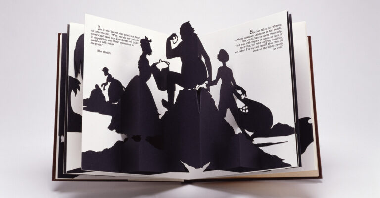 Four black silhouetted figures emerge from the white, open pages of a pop-up book. They appear to be engaged in manual labor. Two of the figures wear full floor-length skirts.