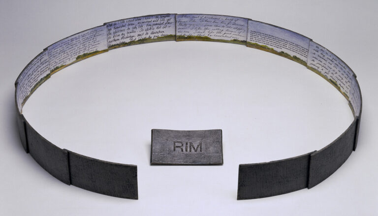Twelve metal sheets overlap to form an incomplete circle. The missing section displays the letters "RIM" and is located inside the circle facing out. A rural landscape painting and text cover the interior of the circle.