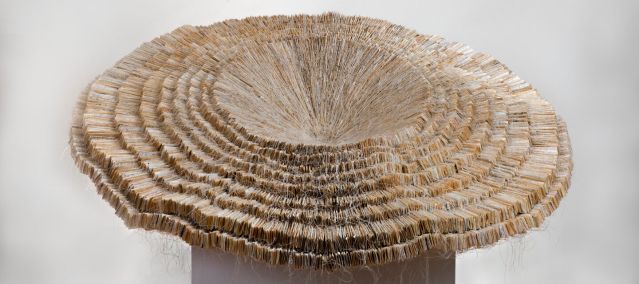Sculpture made of layers of paper that opens like a forest mushroom.