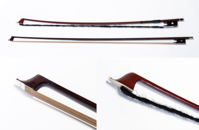 Two wooden violin bows, one strung with straight, smooth blond hair, and the other strung with a dark dreadlock, made from human hair.