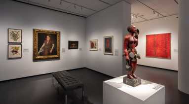 View of a gallery with works of art installed on the walls and on pedestals.