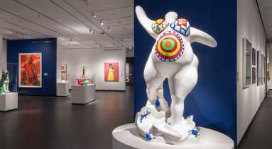 View of a gallery with works of art installed on the walls and on pedestals.