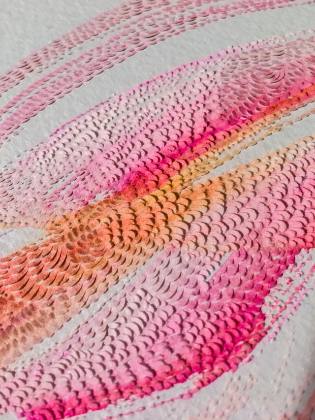 Close-up view of an abstract contemporary artwork of few strokes of pink, orange and magenta watercolors on a white background. The surface of the paint is marked by miniscule shallow raised cuts into the top layer of the paper.