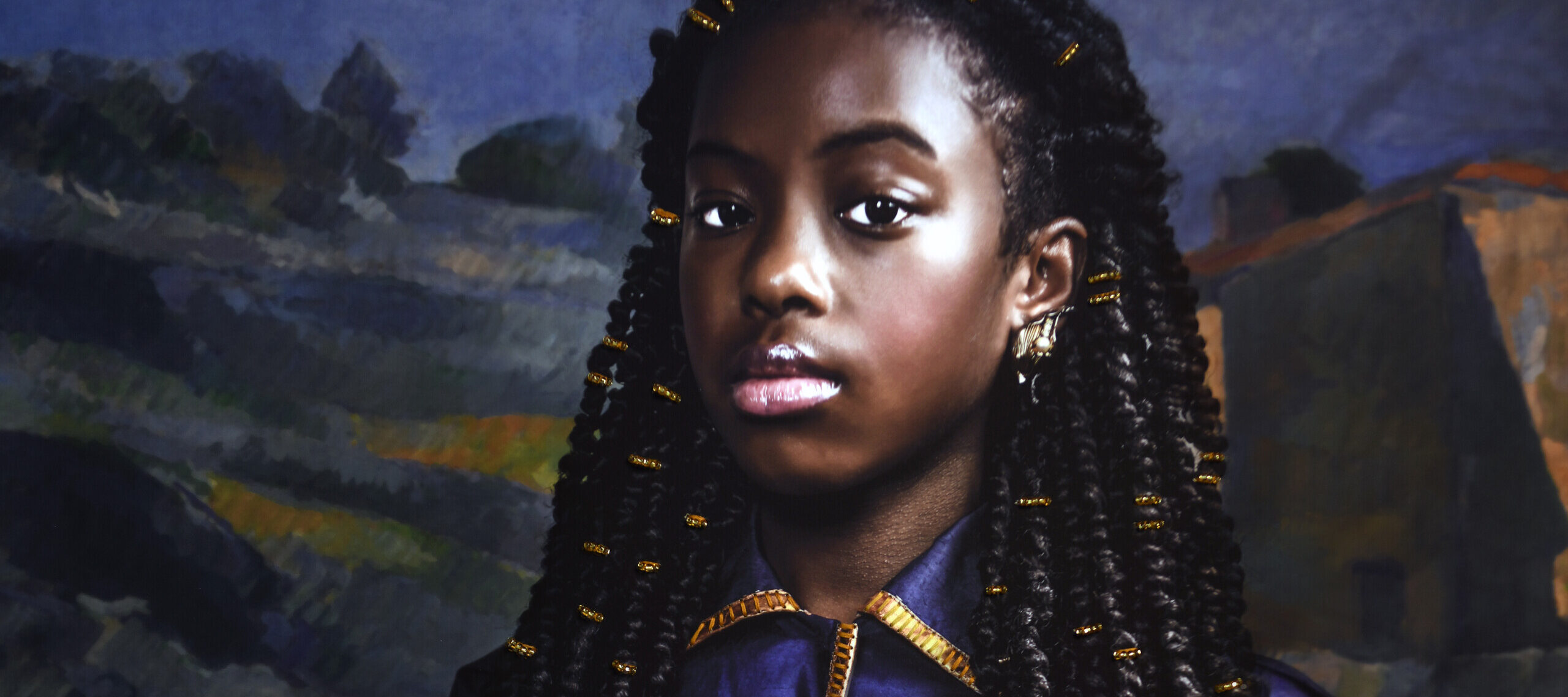 A photograph of a young Black girl. She is seated and wearing a blue dress with gold accents. She holds in her lap a doll, which is dressed in a gold dress and headwrap. The background is a landscape painting by Cezanne.