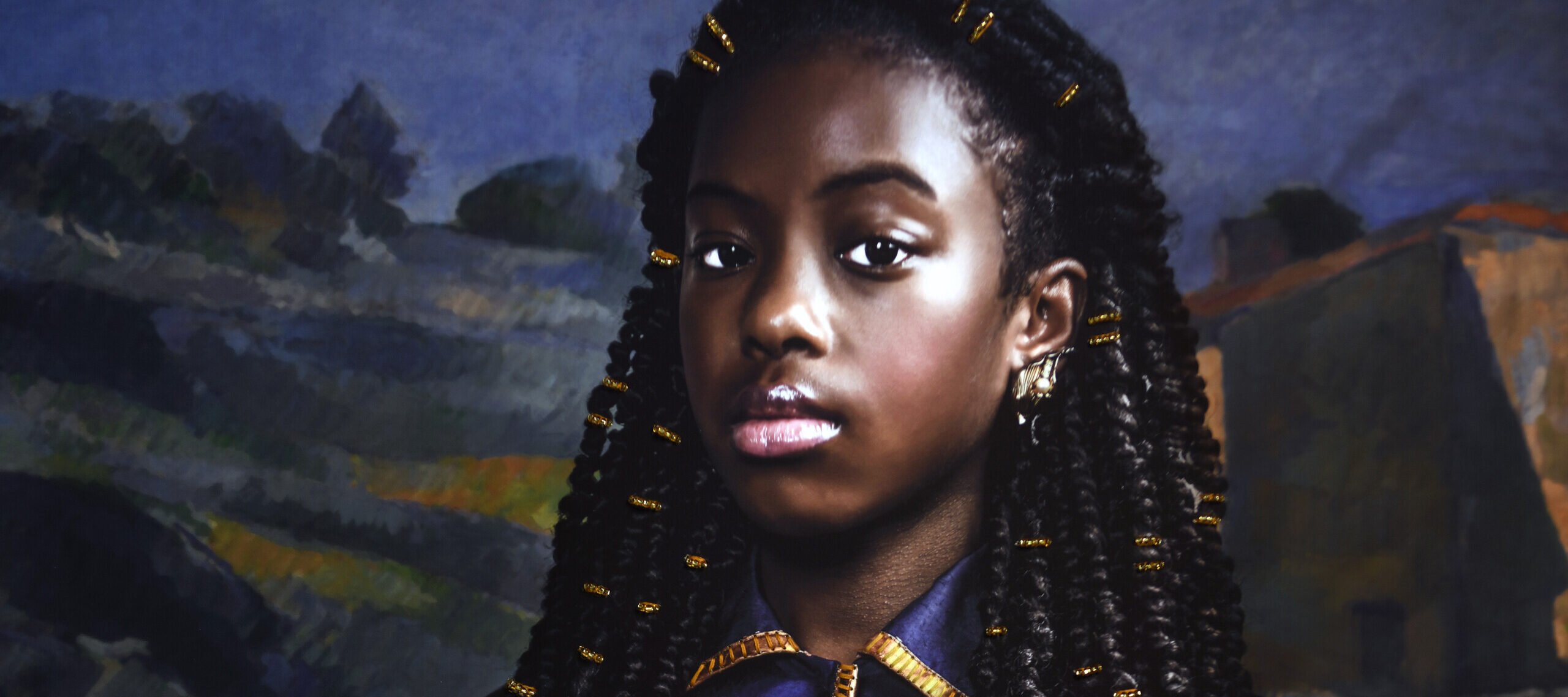 A photograph of a young Black girl. She is seated and wearing a blue dress with gold accents. She holds in her lap a doll, which is dressed in a gold dress and headwrap. The background is a landscape painting by Cezanne.